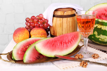 Composition of ripe watermelon, fruits, pink wine in glass and