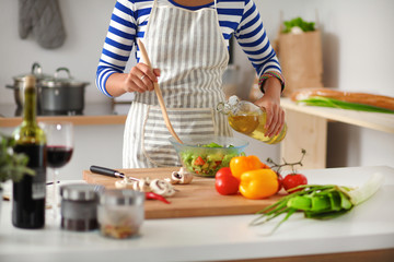 Smiling young woman  mixing fresh salad