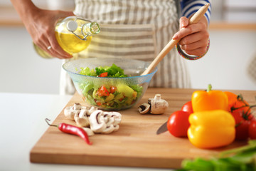 Smiling young woman  mixing fresh salad