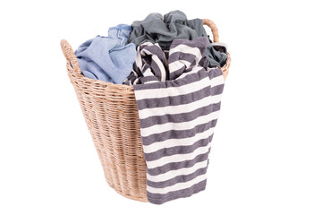 Clothes in a laundry wooden basket isolated on white background