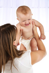 Cute baby boy with mom on light background