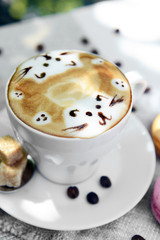 Cup of coffee with cute drawing on table, close up