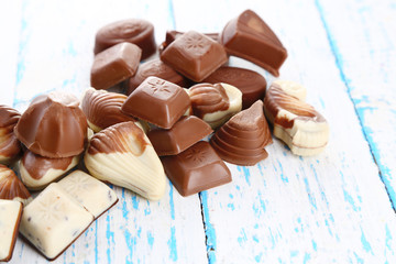 Different kinds of chocolates on wooden table close-up