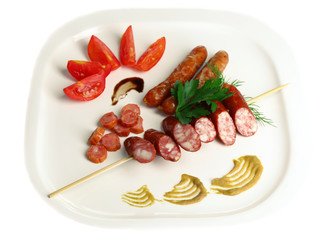 Assortment of tasty thin sausages on plate isolated on white