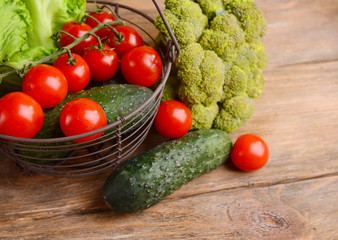 Vegetables in wicker basket on wooden background