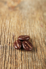 Coffee beans with chocolate glaze on wooden background