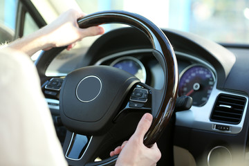 Man's hands on a steering wheel