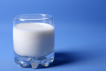 Milk in glass on blue background