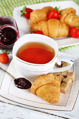 Breakfast with tea, jam and fresh croissants