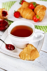 Breakfast with tea, jam and fresh croissants