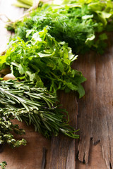 Different fresh herbs on wooden background