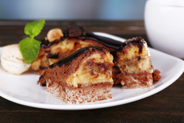 Pieces of chocolate cake on plate and cup of tea on wooden