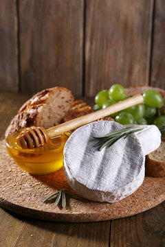 Camembert cheese, bread, honey and grapes