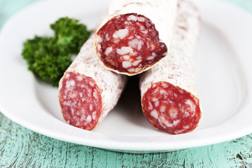 Italian salami on plate,  on wooden background