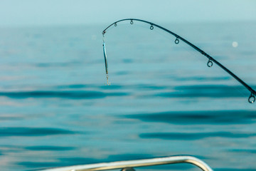 saltwater fishing - rod with wobbler and blue sea water