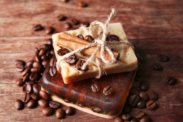 Organic soap with coffee beans and spices on wooden background