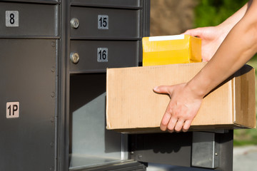 Packages being loaded into postal mailbox