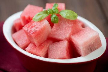 Close-up of watermelon cubes with basil leaves, horizontal shot