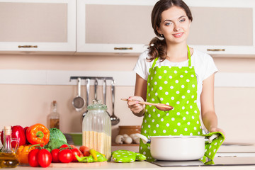 Young Woman Cooking in the kitchen. Healthy Food. Dieting Concep