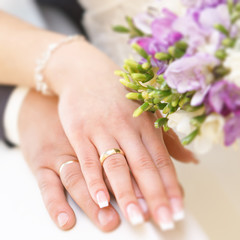 Hands of the groom and the bride with wedding rings