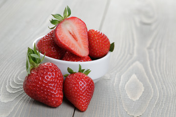 fresh ripe strawberries in a simple white bowl