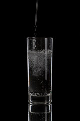 pouring mineral water in simple highball glass