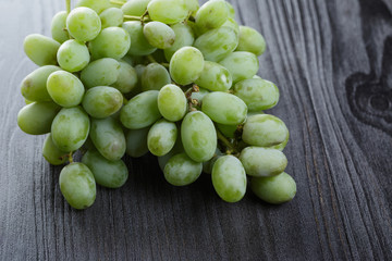 ripe green grapes on black wood table