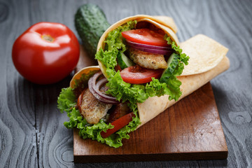 pair of fresh juicy wrap sandwiches with chicken and vegetables
