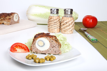 meatloaf with egg tomato and green peas isolated on a white back
