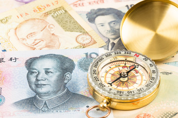 Compass on asian banknote concept financial direction