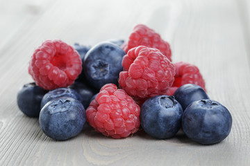 raspberries and blueberries on wood table