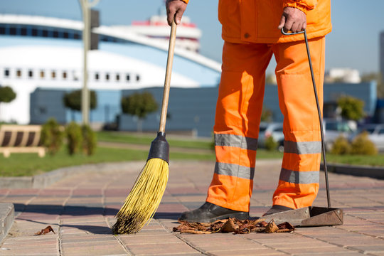 Street Sweeper cleaning footway with broom tool and dustpan