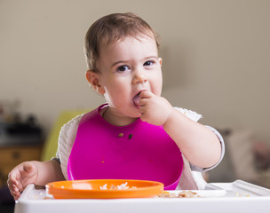cute baby girl eating during meal time