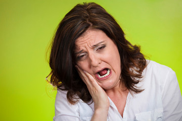headshot woman with sensitive tooth ache green background 