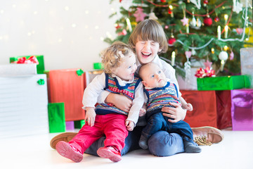 Fototapeta na wymiar Three happy children under decorated Christmas tree