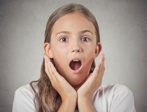 Headshot teenager girl shocked surprised on grey background 