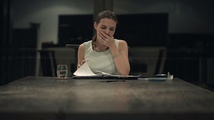 Overworked, tired businesswoman reading documents in the office 