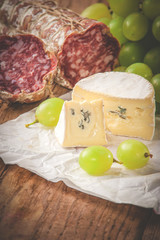 Blue cheese with salami on a wooden rustic table