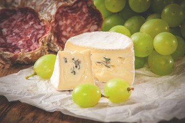 Blue cheese with salami on a wooden rustic table