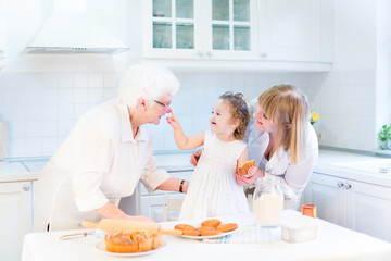 Funny toddler girl in kitchen, having fun baking apple pie