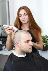 Fototapeta premium young man in a barber shaved shorn