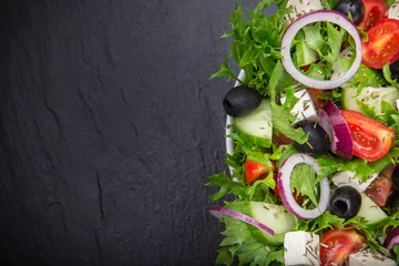 Tuinposter Fresh tasty salad on dark stone table © Lukas Gojda