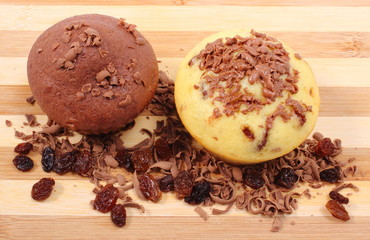 Fresh baked muffins and grated chocolate on wooden cutting board