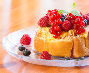 A cake with berries, red currants and fresh mint