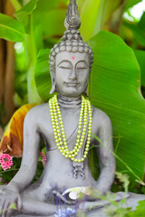 Buddha - Buddhastatue im grünen Garten und Räucherstäbchen