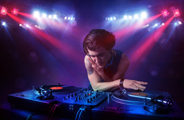 Teenager dj mixing records in front of a crowd on stage