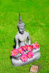Tempel - Buddhastatue mit Blüten und Räucherstäbchen