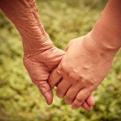 Senior and young holding hands with retro effect
