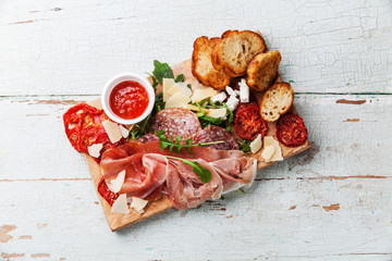 Cold meat plate and bread on wooden background