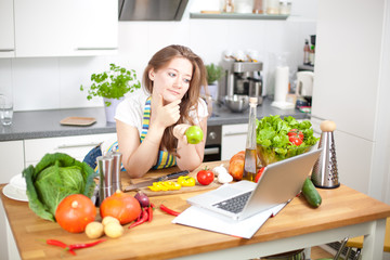 Frau mit laptop in der küche 